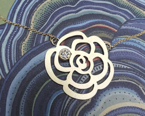 Geboortesieraad, push present. Maatwerk baargoud sieraad. Ontwerp van Oogst Goudsmeden in Amsterdam. Geelgouden camelia met diamant collier. Geboortesieraad, Baargoud.