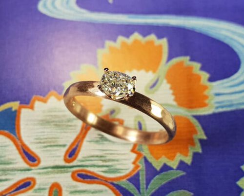 Verlovingsring 'Ritme'. Roodgouden ring met hamerslag en een ovaal geslepen diamant. Engagement ring 'Rhythm'. Rose golden ring with hammering and an oval cut diamond. Uit het Oogst atelier Amsterdam.