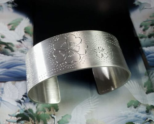 Zilveren klemarmband met handgravure van klavertjes bij de beek. Silver cuff with handengraved clovers. Oogst goudsmeden Amsterdam.