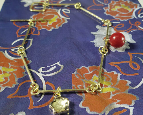 Geelgouden armband met bloesem en koraal. Yellow gold bracelet with a coral and with yellow gold flower. Japonais. Oogst goudsmid Amsterdam