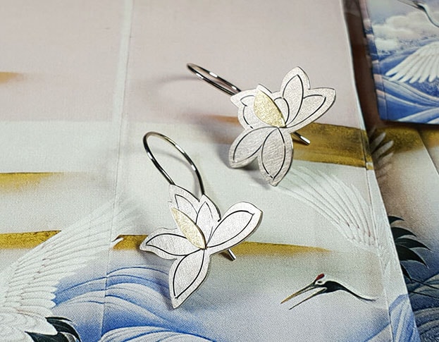 Witgouden Magnolia oorsieraden. White gold magnolia earrings with hand engraving and yellow gold details. Oogst goudsmid Amsterdam