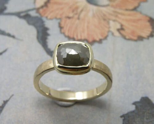 Verlovingsring 'Ritme'. Geelgouden ring met hamerslag en olijfgroene diamant. Engagement ring 'Rhythm'. Yellow golden ring with hammering and olive green diamond. Uit het Oogst atelier Amsterdam.