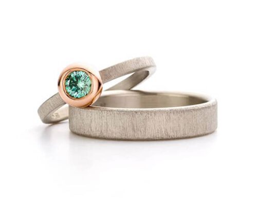 Witgouden trouwringen fluweel. Smalle ring met fancy Paraiba diamant in roodgouden boleet zetting. Oogst goudsmeden Amsterdam.