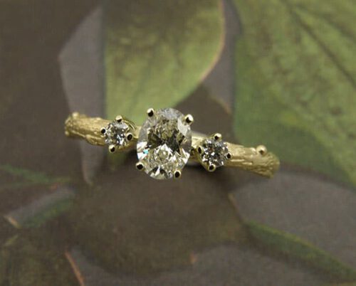 Verlovingsring 'Boomgaard'. Geelgouden takje met een ovale 0,40 crt diamant en 2 0,05 crt diamanten. Engagement ring 'Orchard'. Yellow golden twig ring with oval 0,40 crt diamond and 2x 0,05 crt diamonds. Oogst goudsmeden Amsterdam.