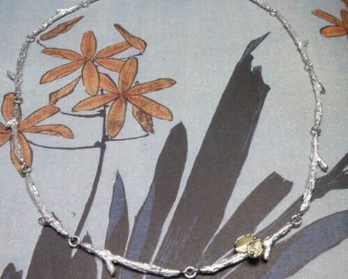 Zilveren takjes schakels met geelgouden blaadjes. Silver twigs necklace with yellow golden leafs. Oogst goudsmeden Amsterdam.