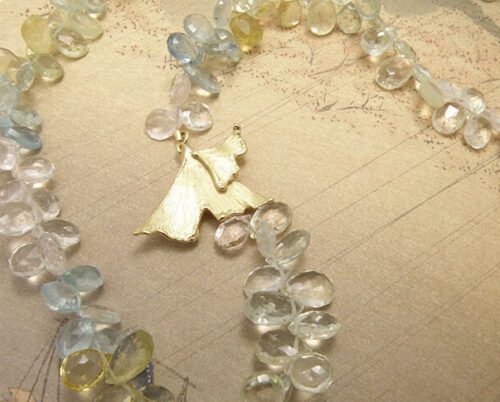 Beryl collier met geelgouden ginkgo biloba blad sluiting. Beryl necklace witch yellow golden ginkgo leaf clasp. Uit het Oogst atelier Amsterdam.