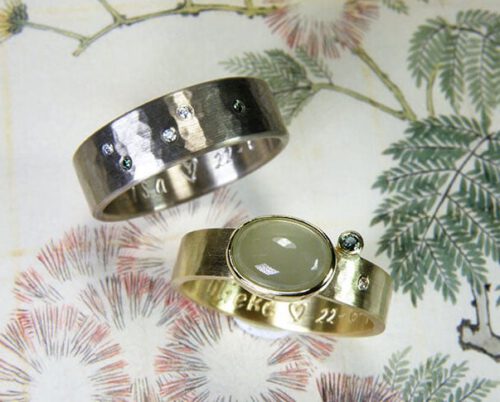 Trouwringen 'Ritme'. Witgouden vlakke ring met fijne hamerslag. Geelgouden vlakke ring met fijne hamerslag en aquamarijn en diamant. Oogst goudsmeden Amsterdam.