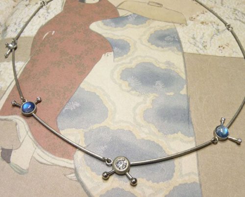 Witgouden collier met diamanten en maansteen Watermolecuul. White gold necklace with diamonds and moonstone Water molecule. Uit het Oogst goudsmid atelier. Made in the Oogst goldsmith studio.
