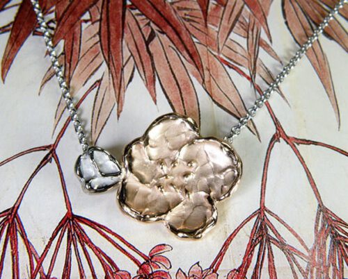 Roodgouden bloesem hanger aan witgouden ketting. Japonais. Rose gold blossom on a white gold chain. Uit het Oogst goudsmid atelier. Made in the Oogst goldsmith studio.