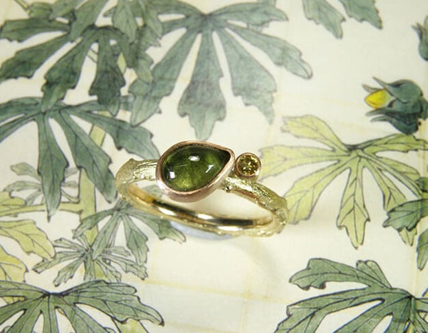 Verlovingsring Ton sur ton geelgouden takje met groene toermalijn en diamant natural olive. Engagement ring Ton sur ton yellow golden twig with green tourmaline and diamond natural olive. Uit het Oogst atelier Amsterdam.
