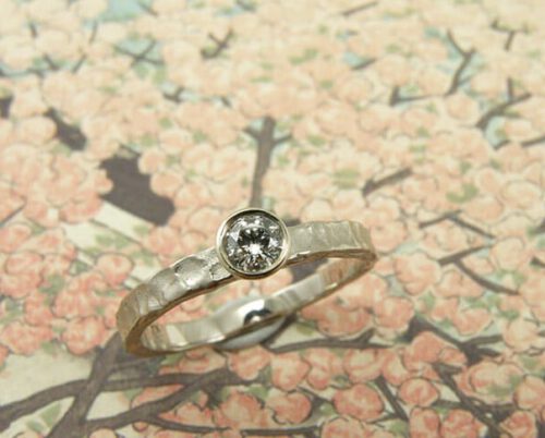 Verlovingsring 'Deinig'. Witgouden ring met structuur en een diamant. Engagement ring 'Swell'. White golden ring with structure and a diamond. Oogst goudsmeden Amsterdam.