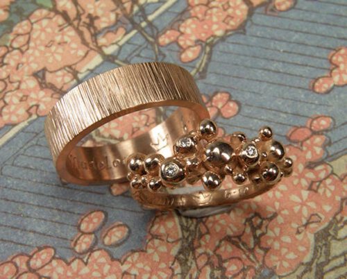 Trouwringen 'Bessen' & 'Ritme'. Roodgouden besjes ring met 3 diamanten uit een erfstuk. Roodgouden vlakke ring met spitse hamerslag. Wedding rings 'Berries' & 'Rhythm'. Rose golden ring with berries and 3 heirloom diamonds. Rose golden ring with hammering. Oogst goudsmeden Amsterdam.