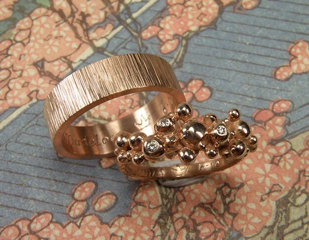 Trouwringen 'Bessen' & 'Ritme'. Roodgouden besjes ring met 3 diamanten uit een erfstuk. Roodgouden vlakke ring met spitse hamerslag. Wedding rings 'Berries' & 'Rhythm'. Rose golden ring with berries and 3 heirloom diamonds. Rose golden ring with hammering. Oogst goudsmeden Amsterdam.