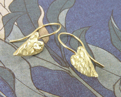 Geelgouden hartjes oorsieraden met stoere structuur en krul. Yellow golden heart earrings with structure. Oogst goudsmeden Amsterdam.