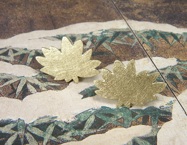 Geelgouden chrysanthum oorstekers uit de 'Japonais' collectie. Yellow golden chrysanthum earstuds from the 'Japonais' collection. Uit het Oogst atelier Amsterdam.