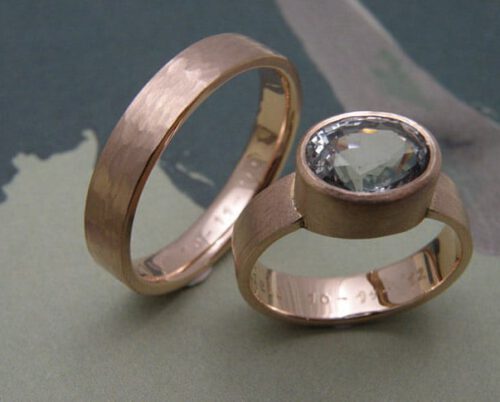 Trouwringen 'Ritme' & 'Saffier'. Roodgouden ring met lijnenstructuur en ovale blauwe saffier. Roodgouden ring met hamerslag. Wedding rings 'Rhythm' & 'Sapphire'. Rose golden ring with line structure and blue oval sapphire. Rose golden ring with hammering. Oogst goudsmeden Amsterdam.