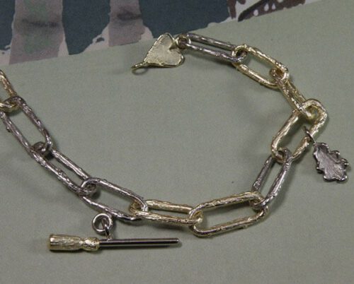 Witgouden met geelgouden armband met bedels. White gold and yellow gold bracelet with charms. Gedenksieraad. Remembrance jewel. Oogst goudsmid Amsterdam