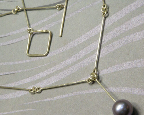 Collier geelgouden staafjes met hamerslag en mauve zoetwater parel. Bruidssieraad. Uit het Oogst goudsmid atelier. Yellow gold necklace with fresh water pearl and hammered links. Made by Oogst Amsterdam. Bridal jewellery.