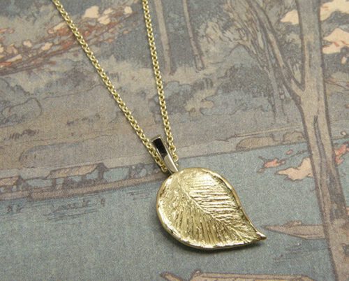 Gedenksieraad. Geelgouden blad hanger met witgouden steeltje. Commemorative jewel. Yellow gold leaf with a white gold twig. Oogst Amsterdam. Handgemaakt uniek gedenksieraad en assieraad.