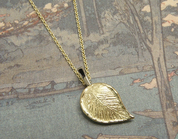 Gedenksieraad. Geelgouden blad hanger met witgouden steeltje. Commemorative jewel. Yellow gold leaf with a white gold twig. Oogst Amsterdam. Handgemaakt uniek gedenksieraad en assieraad.