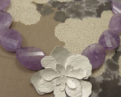 Zilveren hortensia met stofstructuren en amethist. Silver hydrangea necklace with fabric structure and amethyst. Oogst goudsmeden Amsterdam.