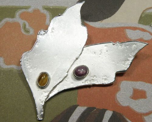 Zilveren broche Bladeren met tijgeroog en ster robijn. Uit het Oogst atelier. Silver brooch Leafs, with tiger eye and star ruby. Made in the Oogst goldsmith studio.