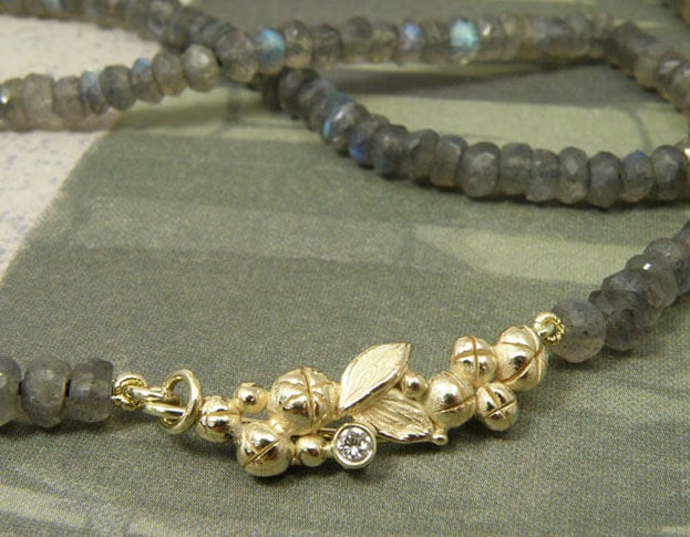 Collier 'Bessen' besjes en bladeren sluiting vervaardigd uit oud goud met eigen diamant aan fonkelende labradoriet. Necklace ‘Berries’ berries and leafs clasp made of heirloom gold with heirloom diamond and sparkling labradorite. Uit het Oogst atelier Amsterdam.