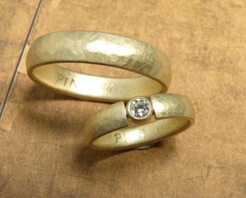 Trouwringen 'ritme'. Geelgouden ring met kussen hamerslag en diamant. Geelgouden ring met kussen hamerslag. Wedding rings 'Rhythm'. Yellow golden ring with hammering and a diamond. Yellow golden ring with hammering. Oogst goudsmeden Amsterdam.