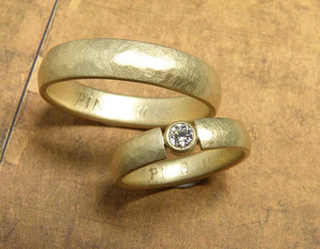 Trouwringen 'ritme'. Geelgouden ring met kussen hamerslag en diamant. Geelgouden ring met kussen hamerslag. Wedding rings 'Rhythm'. Yellow golden ring with hammering and a diamond. Yellow golden ring with hammering. Oogst goudsmeden Amsterdam.