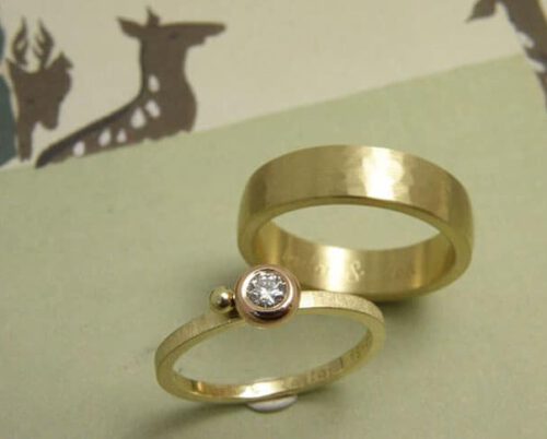 Trouwringen 'Eenvoud' en 'Ritme'. Geelgouden ring met diamant in roodgouden zetting met geelgouden bolletje. Geelgouden ring met kussen hamerslag. Wedding rings 'Simplicity' & 'Rhythm'. Yellow golden ring with sphere and diamond. Oogst goudsmeden Amsterdam.
