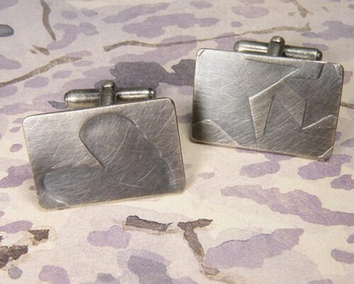 Zilver geoxideerde manchetknopen met verdiept motief van 3 sterren en 1 hart. Silver cufflinks with 3 stars and 1 heart. Oogst goudsmeden Amsterdam.