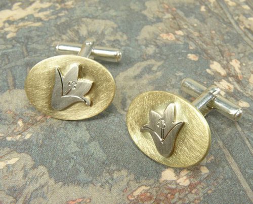Manchetknopen 'In bloei' Geelgouden ovaaltje met witgouden campanula klokjes. Vervaardigd van eigen goud. Maatwerk uit het Oogst atelier Amsterdam. Cufflinks with a flower motive, created from heirloom gold. Design by Oogst.