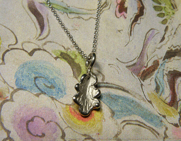 Witgouden eikenblaadje aan verfijnd schakelcollier. White golden oak leaf on fine necklace. Oogst goudsmeden Amsterdam.