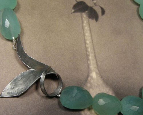 Collier van stukken fluoriet met geoxydeerd zilveren blad als sluiting. Collier made of pieces of fluorite with oxidized silver leaf clasp. Uit het Oogst atelier Amsterdam.
