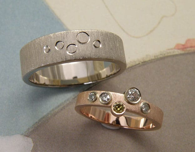 Hand engraved wedding rings 'Lineair'. White gold ring with circles engraving. Rose gold ring with diamonds. Created by Oogst