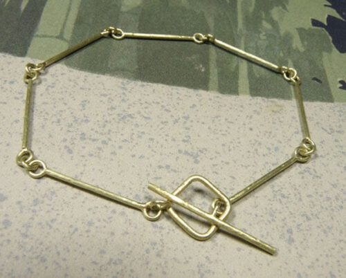 Roodgouden rinkelband met spitse hamerslag. Rose golden hammered bangle. Oogst goudsmeden Amsterdam.