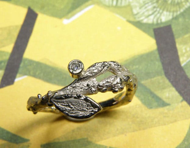Witgouden 'Boomgaard' ring. Speels takje met blaadje en diamant. Oogst goudsmeden Amsterdam