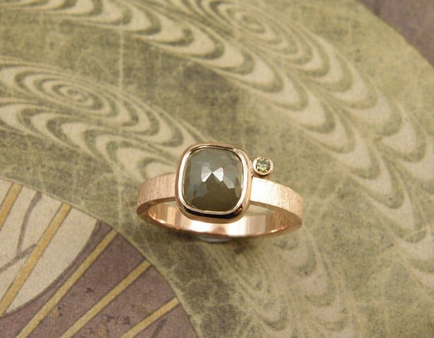 Verlovingsring 'Roos' roodgouden ring met 2,38 crt roosgeslepen kussenvorm diamant en natuurlijk olijfkleur diamant. Engagement ring ‘Rose’ rose golden ring with 2,38 crt rosecut cushion shaped diamond and natural olive diamond. Oogst goudsmeden Amsterdam.