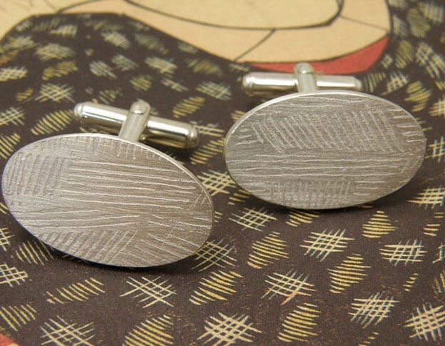 Zilveren ovale manchetknopen met strepen patroon. Silver oval cufflinks with stripes pattern. Oogst goudsmeden Amsterdam.