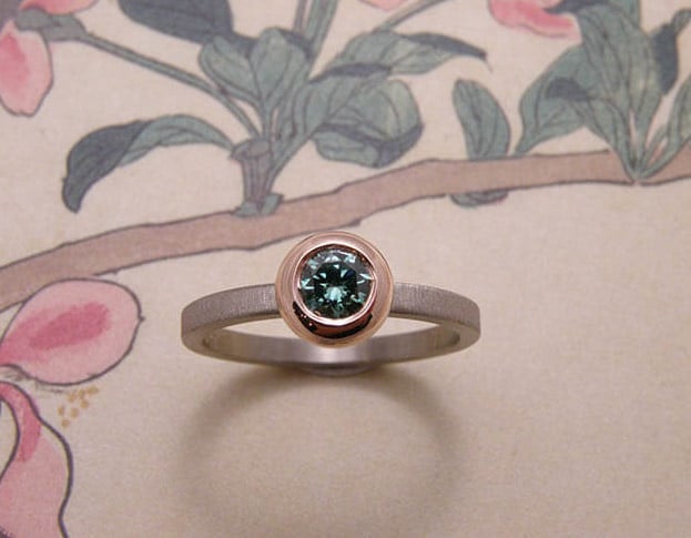 Ring 'boleet' witgouden ring met diamant fancy paraiba groen in een roodgouden boleet zetting met een fluweel afwerking. Ring ‘Boletus’ white golden ring with diamond fancy paraiba green in a rose golden boletus setting with velvet finish. Uit het Oogst atelier Amsterdam.