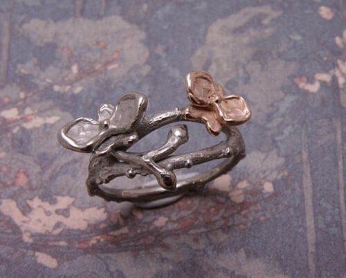 Ring In bloei. Witgouden takjes met orchidee en roodgoud. Ring In boom. White gold twigs with orchids and rose gold details. Uit het Oogst goudsmid atelier. Made in the Oogst goldsmith studio.