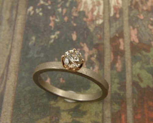 Witgouden ring met diamant in roodgoud zetting. White golden ring with a diamond. Oogst goudsmeden Amsterdam.