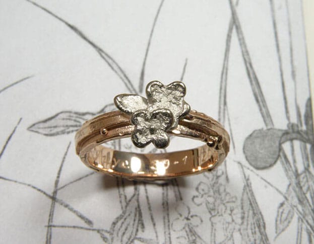 Roodgouden structuur ring met witgouden bloemen. Rose gold textured ring with white gold flowers. Uit het Oogst goudsmid atelier. Made in the Oogst goldsmith studio.