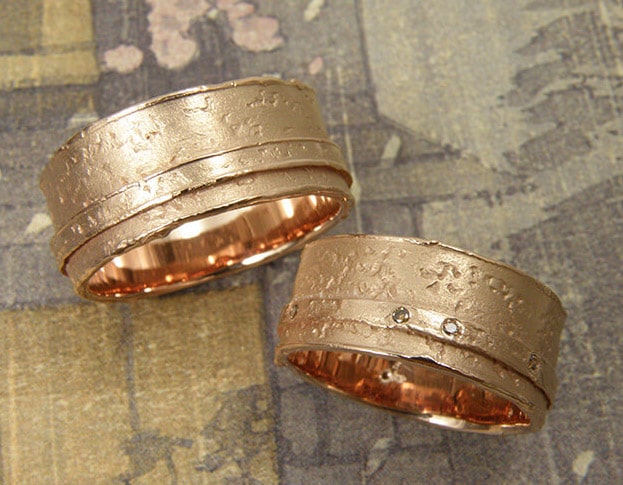 Trouwringen 'Erosie'. Roodgouden brede structuur ring met smalle laag en bruine diamanten. Stoere structuur trouwringen. Oogst goudsmeden Amsterdam.