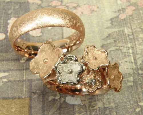 Trouwringen 'In bloei' en 'Eenvoud'. Roodgouden ring met bloemen, waarvan 1 witgoud en een diamant. Roodgouden ring. Wedding rings 'In bloom' & 'Simplicity'. Rose golden ring with flowers, one of which in white gold, and a diamond. Rose golden ring. Oogst goudsmeden Amsterdam.
