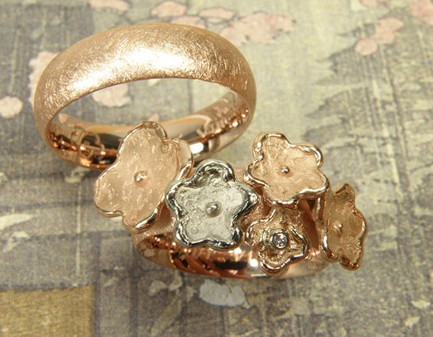 Trouwringen 'In bloei' en 'Eenvoud'. Roodgouden ring met bloemen, waarvan 1 witgoud en een diamant. Roodgouden ring. Wedding rings 'In bloom' & 'Simplicity'. Rose golden ring with flowers, one of which in white gold, and a diamond. Rose golden ring. Oogst goudsmeden Amsterdam.