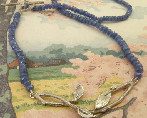 Blog over saffier. Saffier collier met witgouden blaadjes en takjes. Sapphire necklace with white old twigs and leafs. Oogst goudsmid Amsterdam.