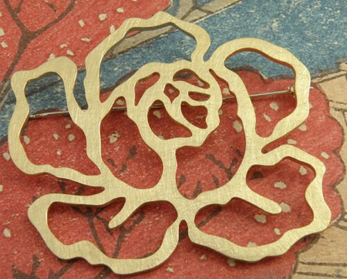 'In bloei' speld in de vorm van een roos, gemaakt van eigen goud. 'In bloom' pin in the shape of a rose, made from heirloom gold. Uit het Oogst atelier Amsterdam.