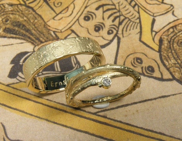Trouwringen Boomgaard & Erosie. Geelgouden stoere trouwringen. Takje met diamant. Oogst goudsmid Amsterdam.