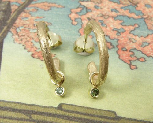 Oorsieraden 'Boomgaard' takjes creolen van eigen goud vervaardigd met 2x 0,05 crt diamant fancy green. Earrings ‘Orchard’ twig earrings made of heirloom gold with 2x 0,05 crt diamond fancy green. Uit het Oogst atelier Amsterdam.